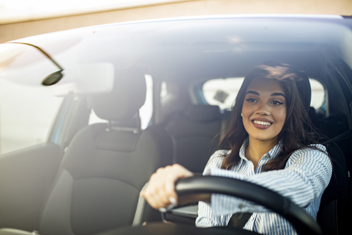 Happy woman driving vehicle