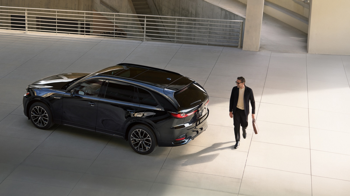 Man walking behind parked 2026 MAZDA CX-70