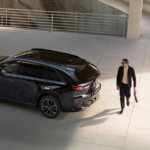 Man walking behind parked 2026 MAZDA CX-70
